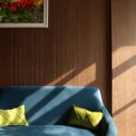 Cozy living room interior featuring a blue sofa, vivid cushions, and wall art.