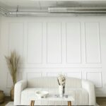 A bright and modern living room with a white sofa and stylish decor, emphasizing minimalism.